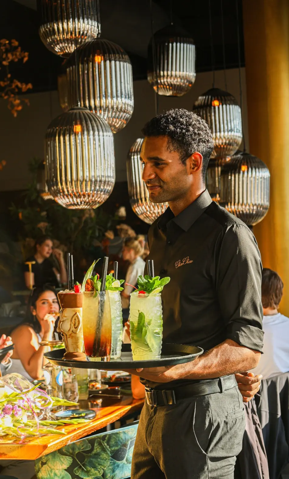 Een collega van ChouChou serveert cocktails in het restaurant
